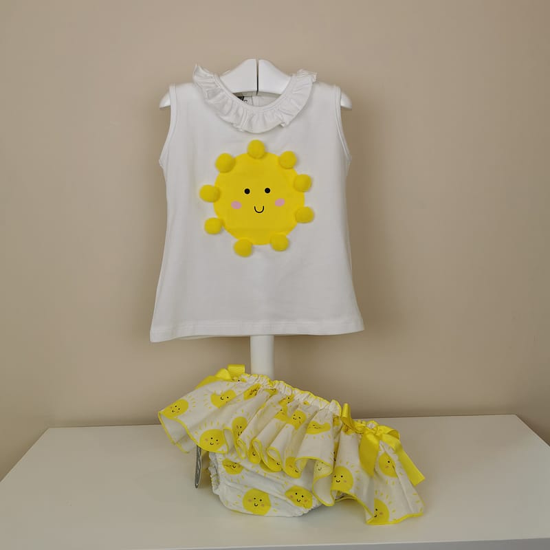 Camiseta manga sisa,volantito en cuello, sol impreso  con detalle de pompones. Braguita con estampado de soles,volante ribeteado en amarillo con lazos laterales.