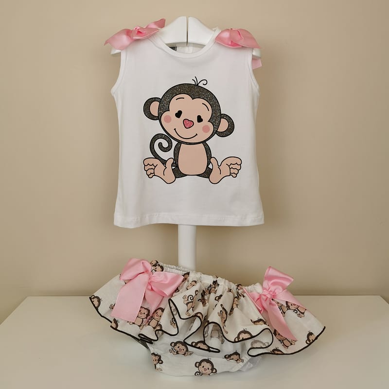 Camiseta blanca manga sisa,monito con detalle de purpurina,lazos en hombros. Braguita con estampado,volante ribeteado en marron, lazadas laterales en rosa.
